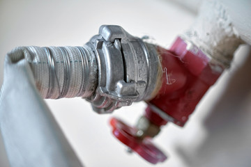 Connection of a fire hose with a red fire cock, close-up