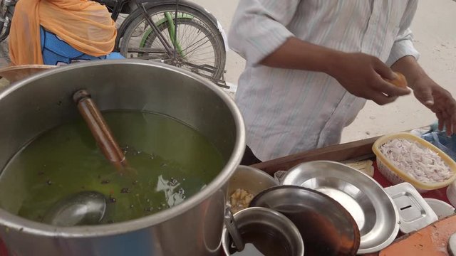 Slow motion prep of Panipuri or Golgappa, consists of a round, hollow puri, fried crisp filled with mix of flavored water, tamarind chutney, chili, chaat masala, potato, atta, chickpea. stabilized 4k
