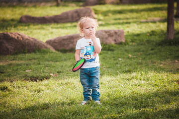 Cute little boy at summer day on green lawn