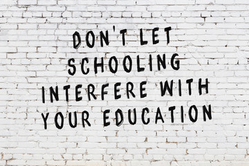 White brick wall with painted black motivational quote inscription