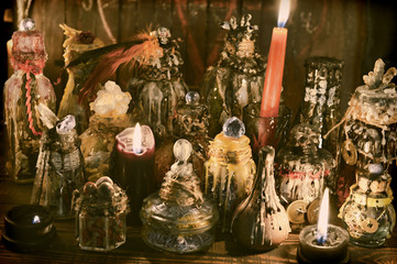 Witch table with decorated magic bottles and burning candles