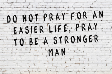 White brick wall with painted black motivational quote inscription