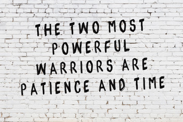 White brick wall with painted black motivational quote inscription