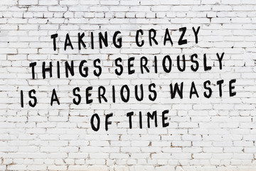 White brick wall with painted black motivational quote inscription