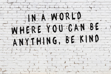 White brick wall with painted black motivational quote inscription