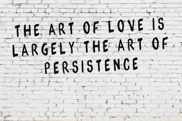 White brick wall with painted black motivational quote inscription