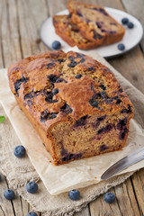 Banana bread on old wooden rustic table, slice of cake with banana, vertical