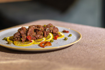 beef tartare with lemon and knife on table near by