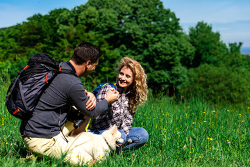Fototapeta premium Young couple enjoying hiking together in nature with they dogs.