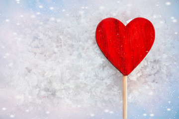 Red Love Heart. Valentine's background. Greeting card. Heart symbol against wood and snow background.