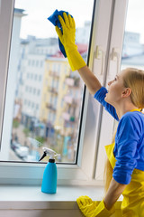 Woman cleaning window at home