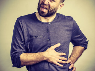 Man having stomach or ribs pain ache.