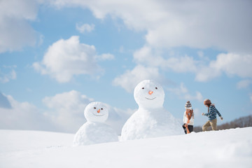 雪だるまと雪遊びをする小学生