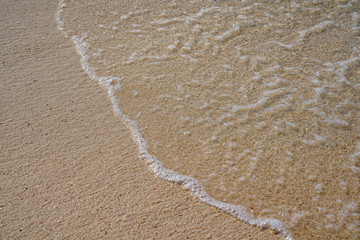 Soft wave of blue ocean on sandy beach Background.
