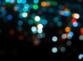 Colorful bokeh night light blur on black background with Christmas background 