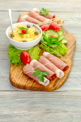 Pieces of Italian prosciutto on a wooden cutting board