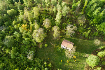 Fototapeta na wymiar Aerial top view of a small house in the woods