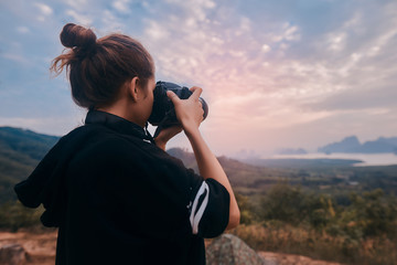 Rear view of a young woman photographer shooting the awesome view of Ao Phang Nga National Park