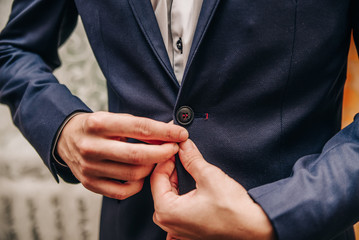 young man buttoning buttons on his jacket