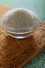 Sugar in glass bowl on wooden background