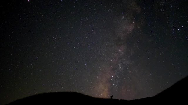The Milky Way galaxy rotating over the mountain range in summer time, several meteors crossed the sky, time lapse movie, 4k version.