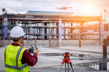 Drone operated by construction worker on building site,flying with drone. - 267540207
