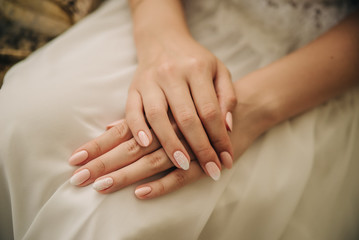 Obraz na płótnie Canvas beautiful hands of a girl on a white wedding dress