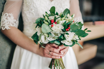 Obraz na płótnie Canvas wedding bouquet with a variety of fresh flowers in the hands of a young bride