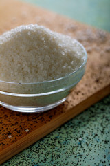 Sugar in glass bowl on wooden background