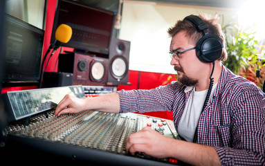 Sound producer working at recording studio using soundboard and monitors