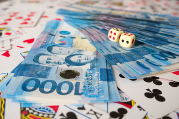 Fototapeta na wymiar Philippines peso cash on a pile of playing cards in the casino