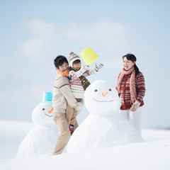 雪だるまを作る家族