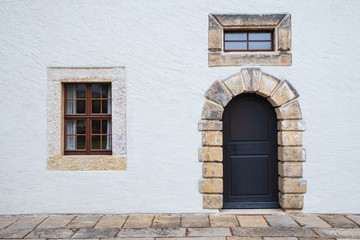 Fototapeta na wymiar Fassade eines weißen Hauses mit Tür und Fenster