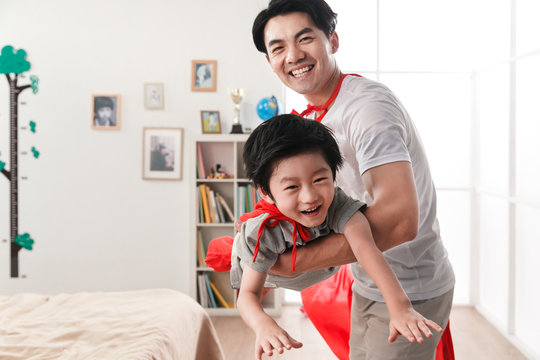 Happy father and son playing a superman