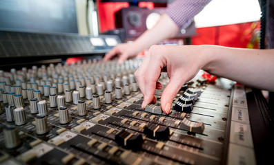 Music engineers working together in recording studio using mixing desk