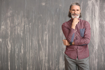 Portrait of handsome mature businessman on grunge background