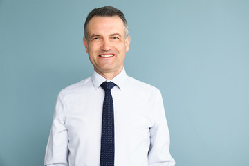 Handsome mature businessman on color background