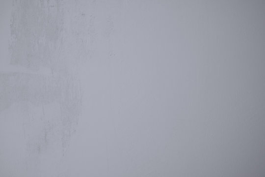 Graublaue Wand im Industrial Design als Hintergrund und Kunst Gestaltung. Verputzte Betonwandwand mit rauen Strukturen und Pastelfarbenen verl&auml;ufen. Hintergrund und Tapetenmuster.