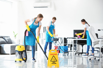 Team of janitors cleaning office