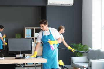 Team of janitors cleaning office