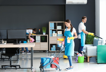 Team of janitors cleaning office