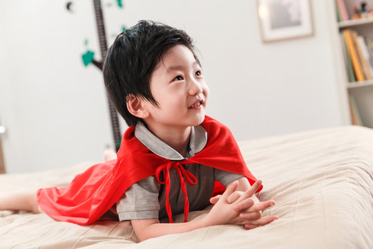 The boy plays a superman