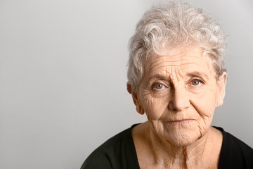 Portrait of senior woman on grey background