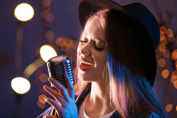Beautiful female singer with microphone on stage