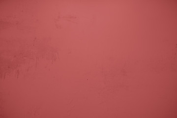 Pastellrote Betonwand mit verputzten Strukturen. Roter Hintergrund im Industrial Design. Strukturierte Steinwand als Textur und gestalterisches Element f&uuml;r Kunst und Kollagen. 