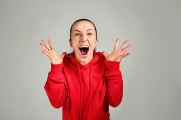 Portrait of angry sporty woman on grey background
