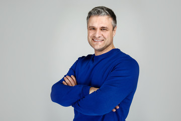 Portrait of handsome mature man on grey background