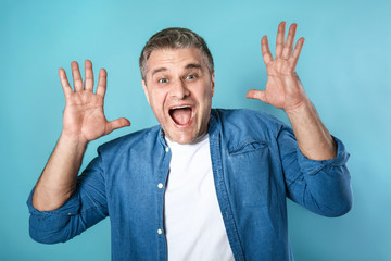Screaming mature man on color background