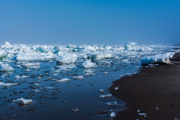 Drifting ice in the sea near the sandy coast. Ice in the sea near the beach © Дмитрий Мишанкин