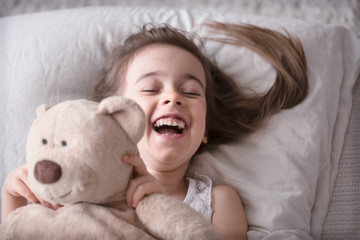 Little cute girl in bed with toy